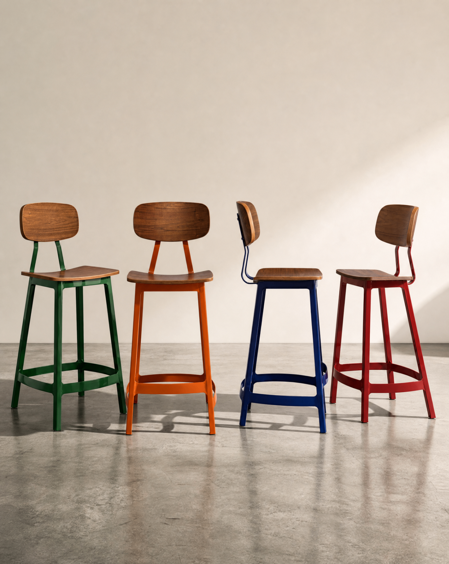 Four Habitus bar stools in green, orange, navy and red with warm walnut plywood seats