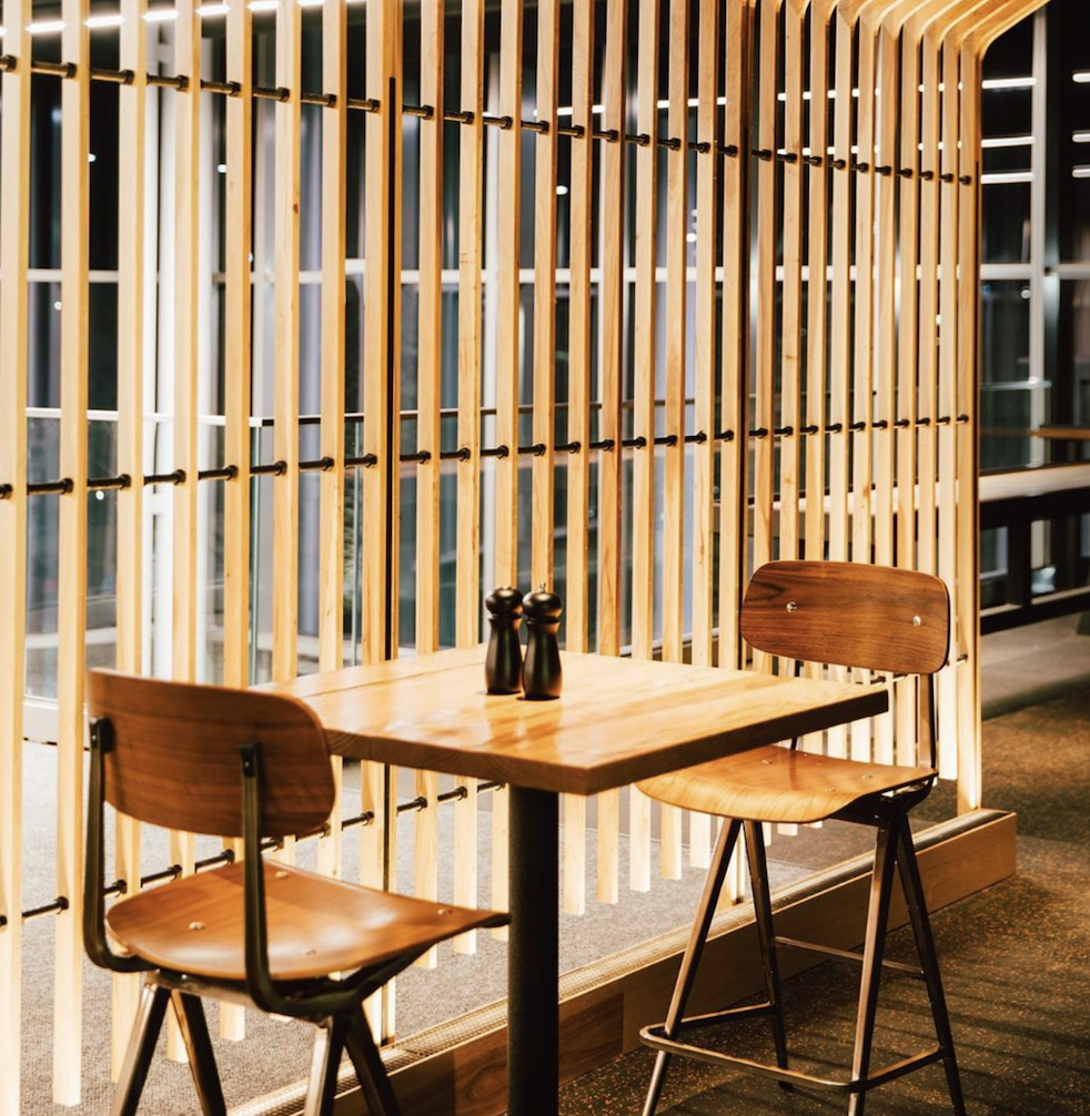 Madewell Collection dining chairs in a warm restaurant setting with timber slat screens