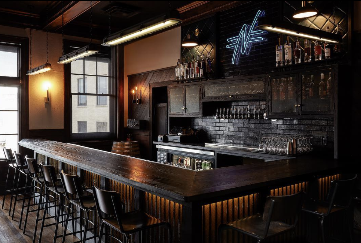 Bar stools at a dark wood bar